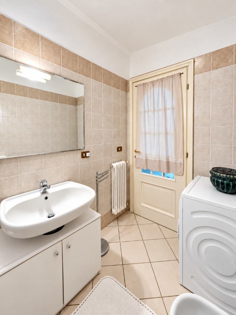 Baño principal, lavabo y lavadora.