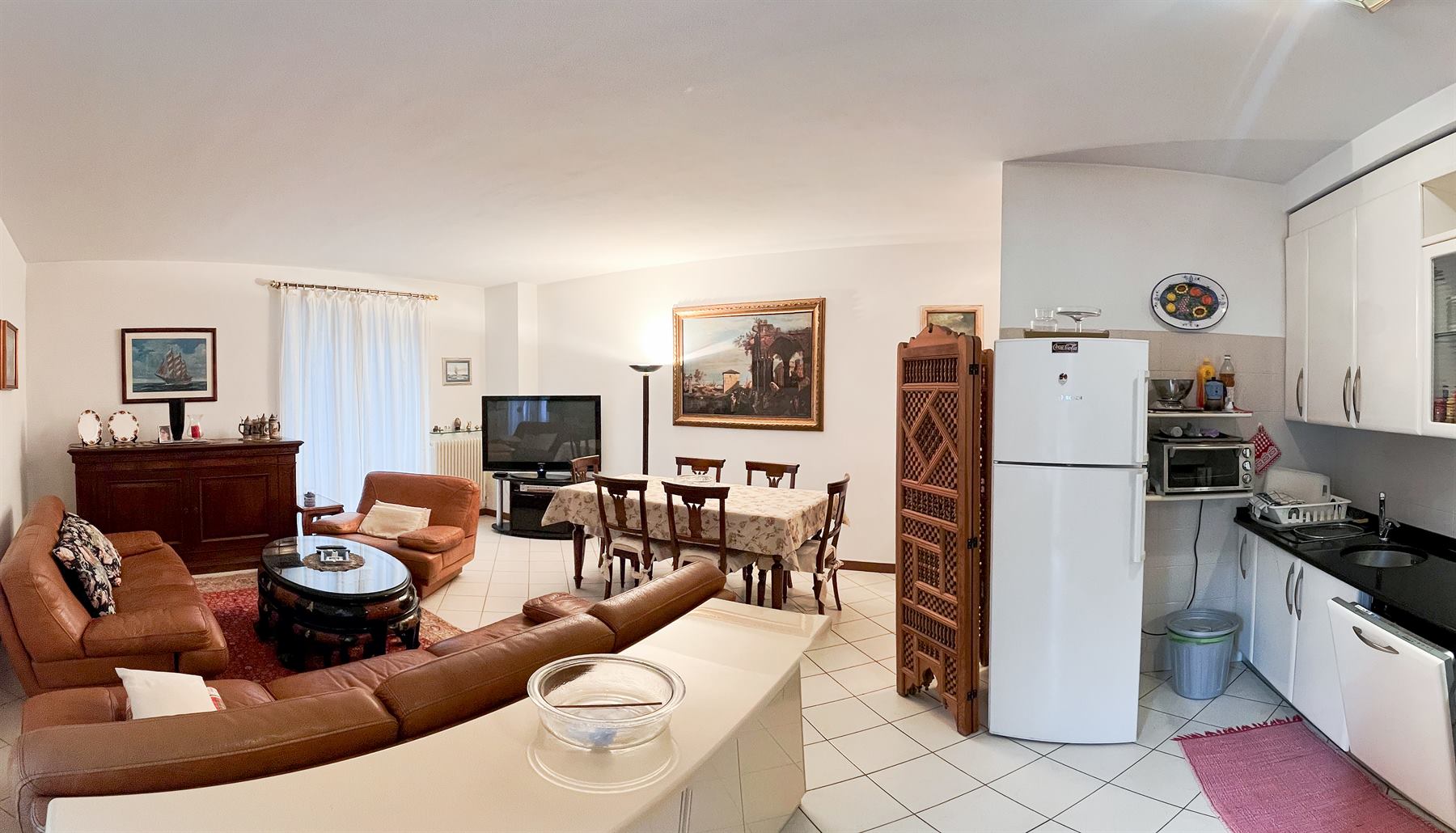 Soggiorno con cucina a vista dell'appartamento arredato.